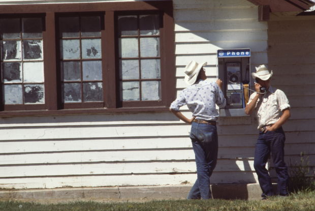 Cowboys using payphone, 1977